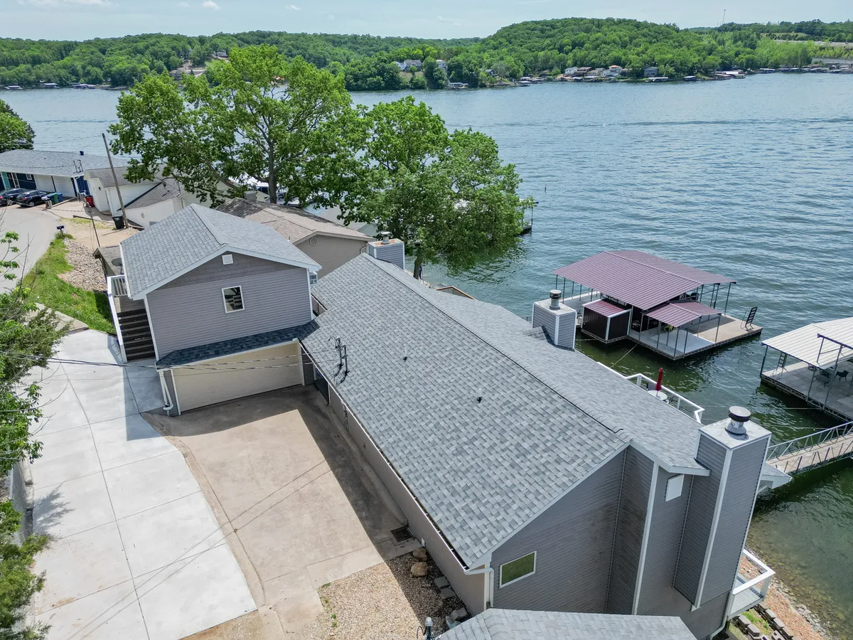 An exterior shot showcasing a waterfront view with a dock, lush greenery, and modern architectural details. The setting radiates tranquility and hints at exclusive lakeside relaxation, with space for enjoying morning coffee or evening gatherings by the water.
