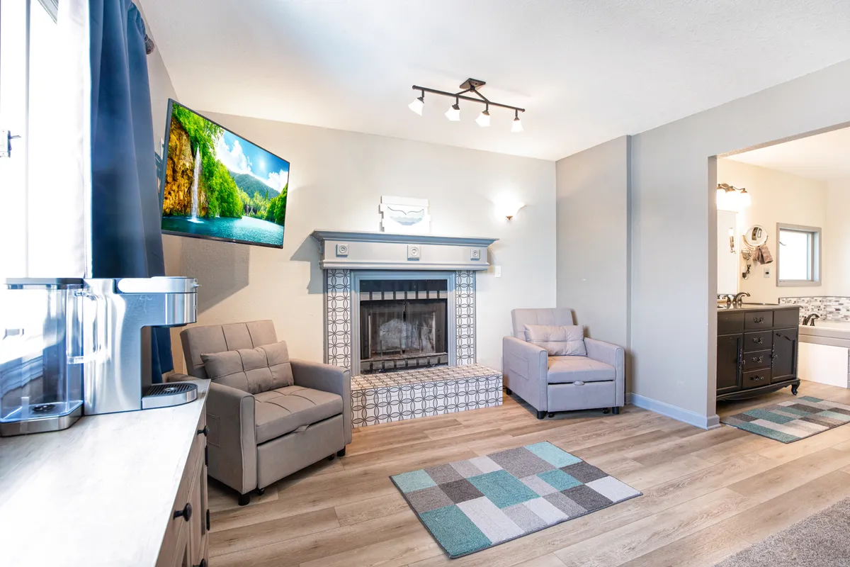 The living area features a cozy fireplace, television, and comfortable seating. The atmosphere is warm and inviting, ideal for relaxing, socializing, or enjoying a quiet evening in.