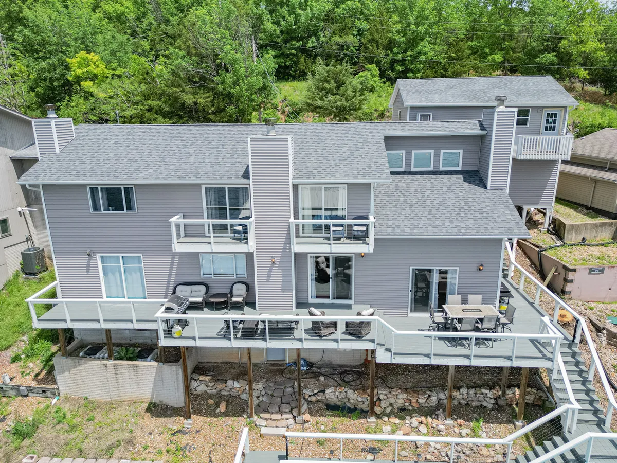 A welcoming exterior view featuring a spacious deck area with comfortable seating, private balconies, and lush greenery. The image conveys an atmosphere ideal for outdoor dining, relaxing, or entertaining guests, capturing the essence of personalized comfort and leisure.